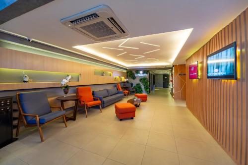 a lobby of a hospital with orange chairs and a waiting room at Intercity Salvador in Salvador