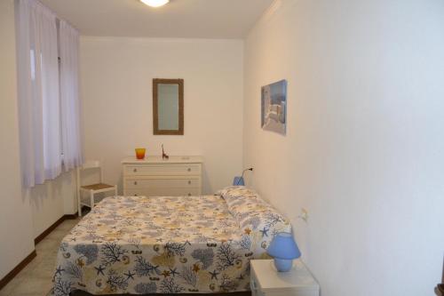 - une petite chambre avec un lit et une commode dans l'établissement Residence Loggetta Margherita, à San Vincenzo
