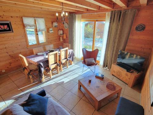 - un salon avec une table dans une cabine dans l'établissement Chalet en bois 6 pers. avec terrasse Sud, lumineux et équipé, animaux admis – Saint-Michel-de-Chaillol - FR-1-393-12, à Saint-Michel-de-Chaillol