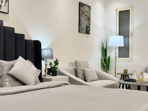 una camera da letto con un letto, un divano e una sedia di استديو مودرن في الشمال بطابع فني والوان هادئة a Riyad