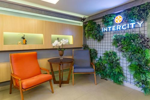 a waiting room with two chairs and a table at Intercity Salvador in Salvador