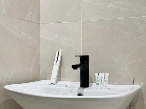 un lavandino con rubinetto e due spazzolini da denti di استديو مودرن في الشمال بطابع فني والوان هادئة a Riyad