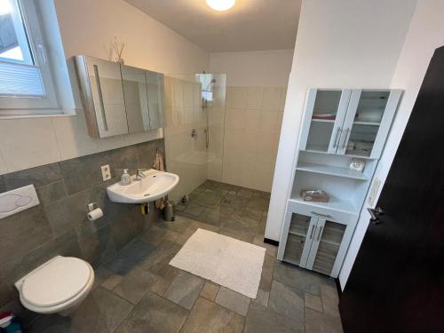 een badkamer met een wit toilet en een wastafel bij Ferienwohnung in ländlicher Idylle in Meschede