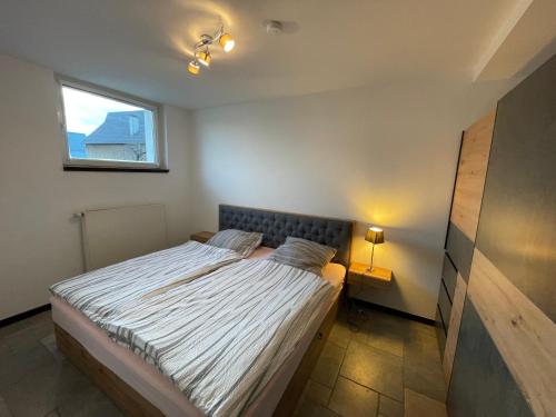 een kleine slaapkamer met een bed en een raam bij Ferienwohnung in ländlicher Idylle in Meschede