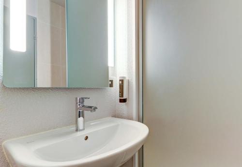a bathroom with a white sink and a mirror at B&B HOTEL Beaune Sud 1 Palais des Congrès in Beaune