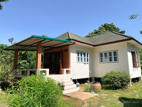 a small white house with a roof at Baan Ko Little House in Ban Rai Khlong Sai