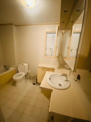 une salle de bain avec un lavabo et des toilettes et une fenêtre dans l'établissement Villa 5mn mer, 8pers, 100m2, grande terrasse, clim, à La Grande Motte