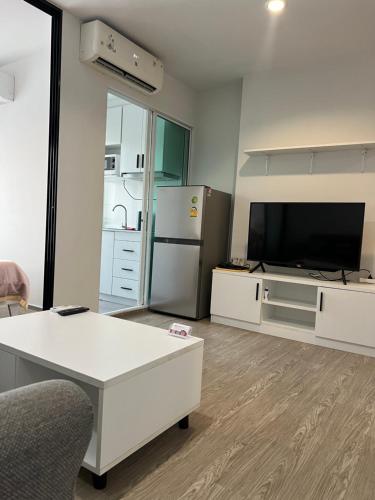 a living room with a white table and a refrigerator at GM bangson home in Bangkok