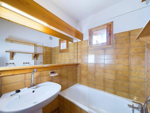 une salle de bain avec un lavabo et une baignoire dans l'établissement Appartement chaleureux refait à neuf, 2 pièces, centre station - FR-1-398-503, à La Rosière