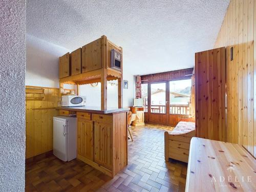 une cuisine avec des armoires en bois et un comptoir dans l'établissement Studio cosy au pied des pistes, balcon exposé sud, centre-station, idéal pour 4 personnes - FR-1-398-570, à La Rosière