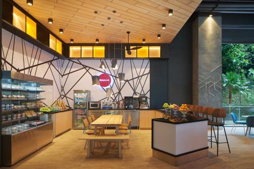 a restaurant with a table and chairs in a room at Aloft Langkawi Pantai Tengah in Pantai Cenang
