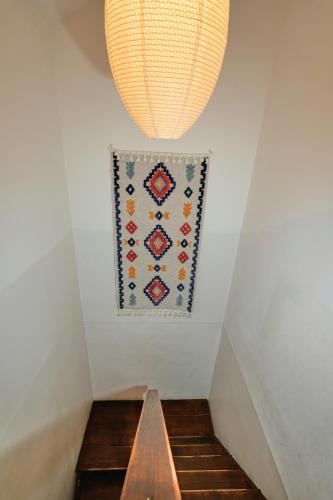 a rug hanging on a white wall next to a stairway at Пе́трови Вили in Ribarica
