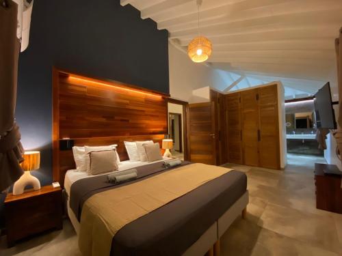 a bedroom with a large bed with a wooden headboard at Villa passion vanille in Les Trois-Îlets