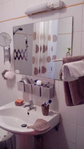 une salle de bain avec un lavabo et un miroir dans l'établissement petit appartement cosy, à Luchon