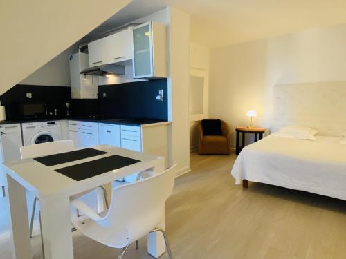 une chambre avec un lit et une cuisine avec une table dans l'établissement GRAND STUDIO DE STANDING HYPER Centre, à Rodez