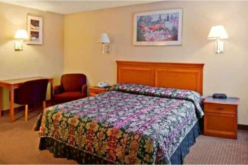 a hotel room with a bed and a chair at Fairview Inn By OYO Hesston I-135 in Hesston