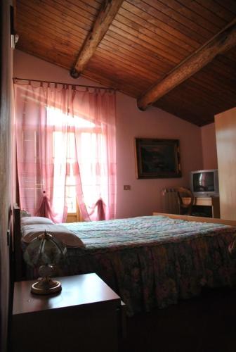 a bedroom with a bed and a window and a table at Il Ghiro B&B in Riccò del Golfo di Spezia