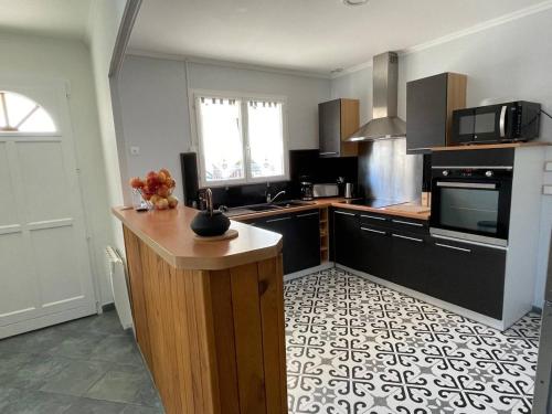 a kitchen with a counter and a stove top oven at Maison 3 chambres - 8 personnes - Elne - AR000-E12 in Elne