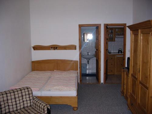 a small bedroom with a bed and a sink at Penzion 102 in Pardubice