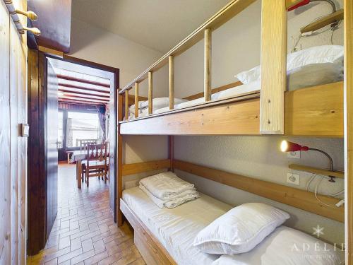 une chambre avec deux lits superposés et une table dans l'établissement Studio cabine pour 4 pers. au pied des pistes avec terrasse et parking, Montvalezan - FR-1-398-648, à Montvalezan