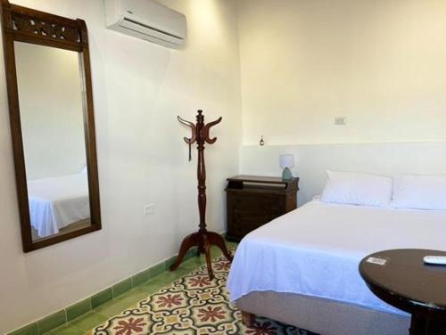 a bedroom with a bed and a mirror and a table at Casa Belia in Cartagena de Indias