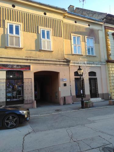 a black car parked in front of a building at Apartman DRAGIN SAN in Subotica