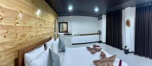 a room with a bed with a wooden wall at Will Guest Homestay in Ella