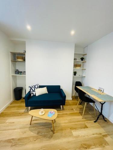 un salon avec un canapé bleu et une table dans l'établissement Le Gambetta - 2 voyageurs - Wifi, au Mans