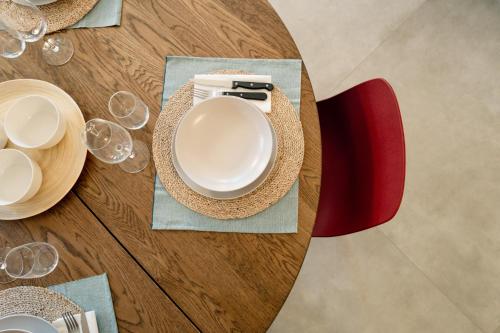 a table with a white plate and a red chair at Albereto 41 in Calenzano