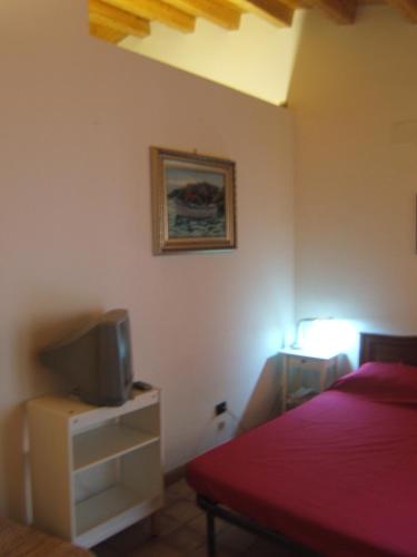 a bedroom with a bed and a tv on a cabinet at Olivella Suite Ecological House in Palermo