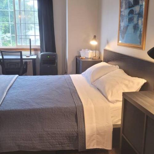 a bedroom with a large bed with a desk and a window at Sunstone House in Portland