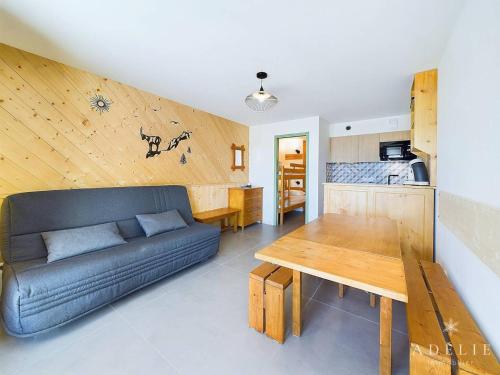 un salon avec un canapé et une table en bois dans l'établissement Studio spacieux rénové, exposition sud, proche des pistes - FR-1-398-669, à Montvalezan