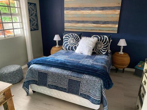un perro blanco acostado en una cama en un dormitorio en Whispering waves, en Gamtoosriviermond