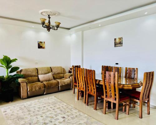 a living room with a couch and a table and chairs at ALEX HOMES - Stanley Cozy Apartments with Direct Sea View in Alexandria