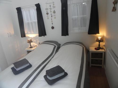 ドンブルグにあるLuxe Appartement Duinoordのベッドルームにタオル2枚が付いたベッド1台