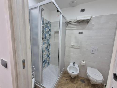 a bathroom with a toilet and a glass shower at Appartamento Annunziata in Naples
