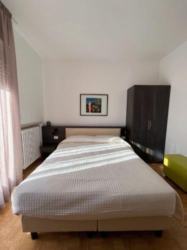 a bedroom with a large bed and a wooden cabinet at BB Rooms in Forlì