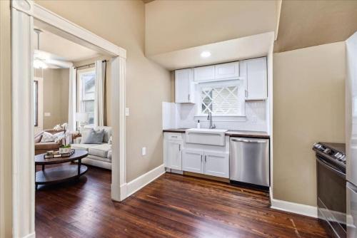 a kitchen with white cabinets and a living room at Historic Suite Downtown Macon - Unit 2 in Macon