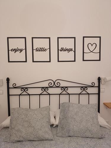 a bedroom with a bed with four pictures on the wall at VUT Casa de la Catedral Baja in Sigüenza