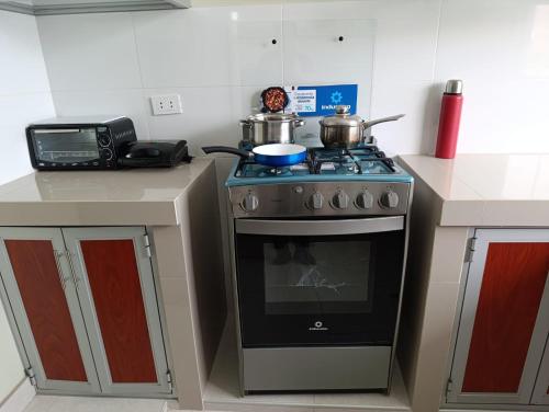 a kitchen with a stove with pots and pans on it at Casa de campo valle de Pachia - Fundo Paris in Huaycuyo