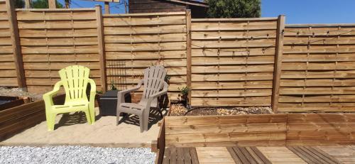 2 chaises assises sur une terrasse en face d'une clôture dans l'établissement Soulac, à 150m de la plage et proche centre-ville maison 8 personnes, à Soulac-sur-Mer
