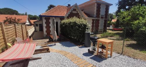 une arrière-cour avec une maison et un hamac dans l'établissement Soulac, à 150m de la plage et proche centre-ville maison 8 personnes, à Soulac-sur-Mer