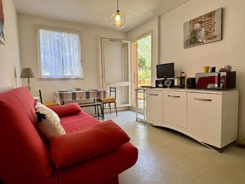 un salon avec un canapé rouge et une télévision dans l'établissement Studio 2 couchages ARGELES SUR MER AR450-0602, à Argelès-sur-Mer
