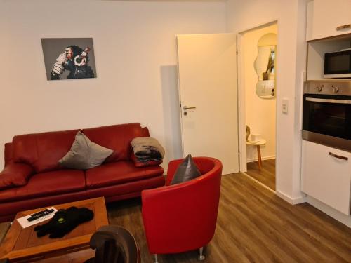 a living room with a red couch and a table at Pilgrims "Dobby" 1 SZ wifi in Brilon