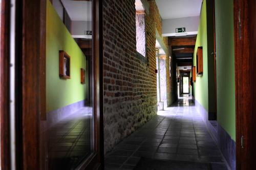 an empty hallway with green walls and a brick wall at B&B L'Epicurie in Hoegaarden