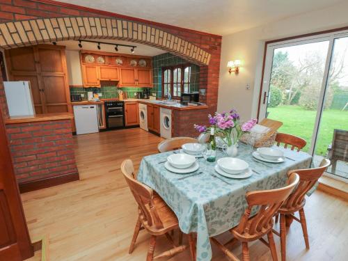 a dining room with a table with chairs and a kitchen at The Chapel in Newport