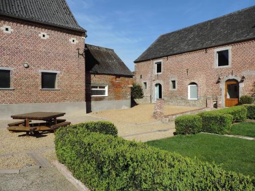 a picnic table in front of two brick buildings at B&B L'Epicurie in Hoegaarden