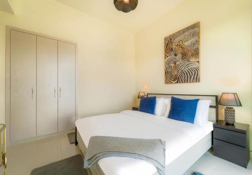 a bedroom with a white bed and a painting on the wall at Dubai Private Pool villa Damac Hills 2 deleguest in Dubai