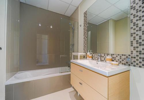 a bathroom with a tub and a sink and a shower at Dubai Private Pool villa Damac Hills 2 deleguest in Dubai