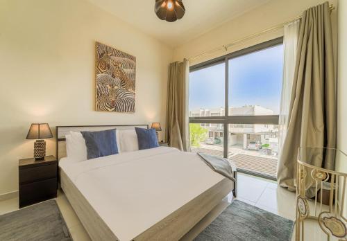a bedroom with a bed and a large window at Dubai Private Pool villa Damac Hills 2 deleguest in Dubai